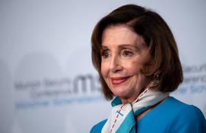 Nancy Pelosi In Blue Attire Wearing A Scarf Wallpaper