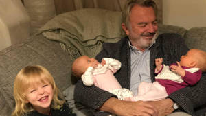 New Zealand Actor Sam Neill With Grandkids Wallpaper