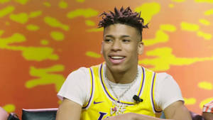 Nle Choppa Posing In Front Of A Lakers Backdrop Wallpaper