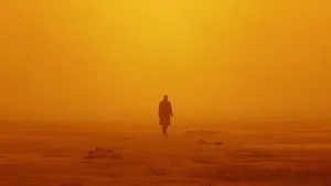 Officer K (ryan Gosling) Walking Through A Post-apocalyptic Desert In Blade Runner 2049 Wallpaper