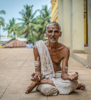 Old Hindu Man Meditating Outdoors Wallpaper