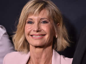 Olivia Newton John In Baby Pink Coat Wallpaper