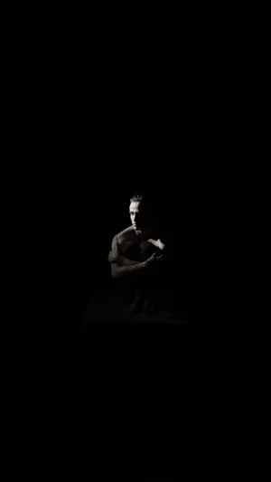 Ominous Man Sitting In The Dark Wallpaper
