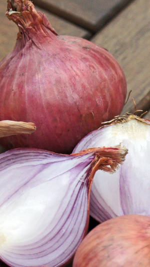 Pale Red Onions On Wooden Planks Wallpaper