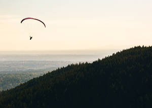 Paragliding Near Coastal Mountain Wallpaper