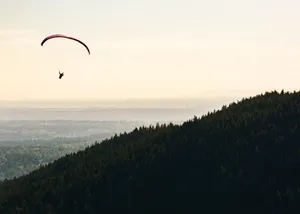 Paragliding Near Coastal Mountain Wallpaper