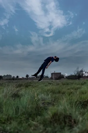 Paranormal Floating Man Above Grass Wallpaper