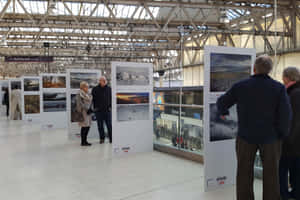 People Looking At Waterloo Station Exhibit Wallpaper