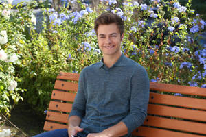 Peyton Meyer Sitting On Bench Wallpaper