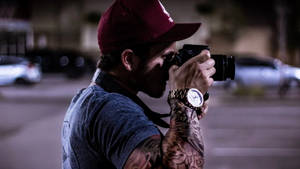 Photographer Capturing A Shot In An Urban Setting Wallpaper