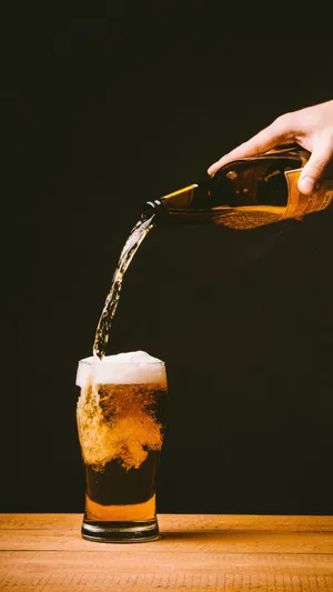 Pouring Glass Of Alcohol With Bubbles Wallpaper