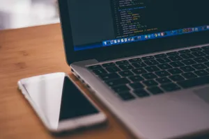 Premium Gray Laptop Next To An Iphone Wallpaper