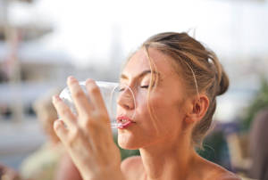 Pretty Woman Drinking Water From Glass Wallpaper