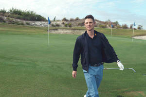 Professional Golfer Justin Rose Confidently Walking On A Golf Course. Wallpaper