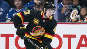 Quinn Hughes Wearing Old Jersey While Focusing On The Game Wallpaper