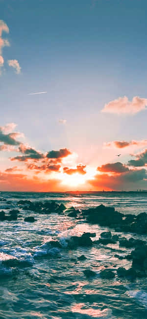 Radiant Sunset Cloud Over A Tranquil Ocean Wallpaper