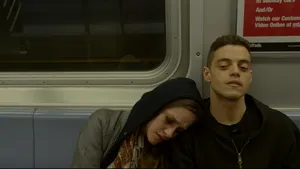 Rami Malek With Woman On Train Wallpaper