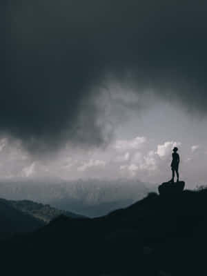 Random Person Standing On Top Of Rock Wallpaper