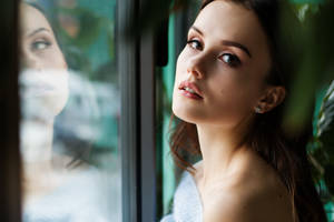 Reflective Mindset - Mature Woman Gazing Through The Window Wallpaper