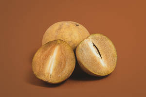 Ripe Sapodilla Fruits On A Rustic Setting Wallpaper