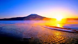 Rising Sun Over A Mountain Lake Wallpaper