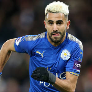 Riyad Mahrez With A Playful Expression On The Field Wallpaper