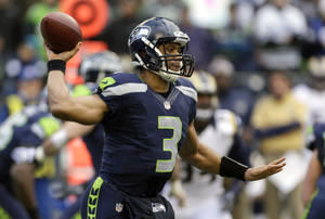 Russell Wilson Holding Football Up Wallpaper