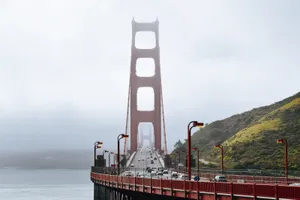 San Francisco’s Iconic Fog Rolling Over The Bay Bridge. Wallpaper