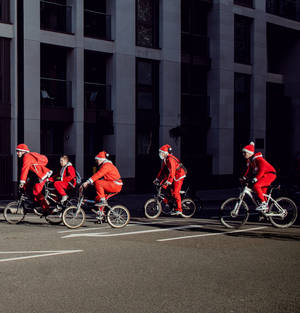 Santa Claus Taking A Break And Enjoying A Breezy Bike Ride Wallpaper