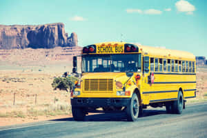 School Bus Traveling Near Monument Valley Wallpaper