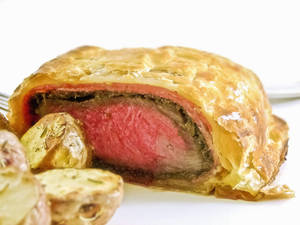 Scrumptious Beef Wellington With A Side Of Garlic Bread Wallpaper