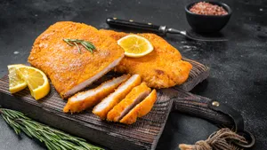 Scrumptious Wiener Schnitzel Served With Lemon Wedges And Parsley Garnish Wallpaper