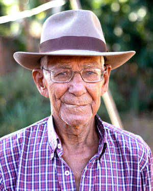 Senior Gentleman In Style With Fedora Hat And Checkered Shirt Wallpaper