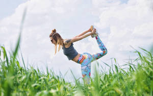 Serenity In Action - Enthralling Low Angle Shot Of Yoga Pose Wallpaper