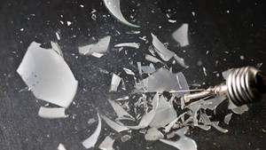 Shattered Illumination: A Broken Light Bulb Wallpaper