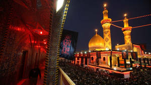 Shimmering Baghdad Mosque At Night Wallpaper