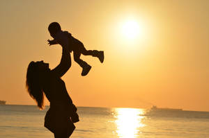 Silhouette Of Mother In Beach Wallpaper