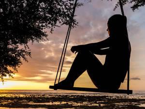 Silhouette Woman On Swing Wallpaper