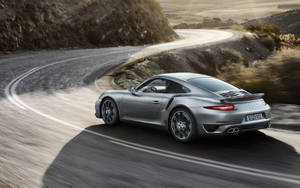 Silver Porsche 911 Racing Down The Road Wallpaper