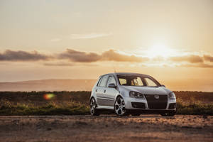 Silver Volkswagen Golf Gti In Sunset Wallpaper