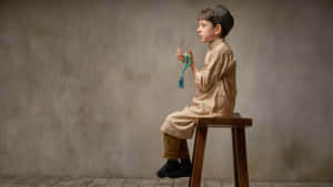 Sitting Muslim Boy Serious Face Wallpaper