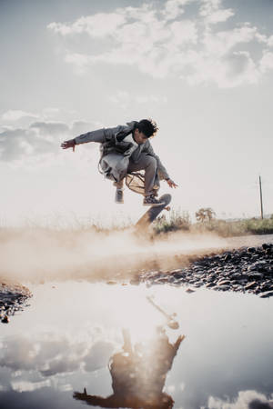 Skateboarder Performing A Daring Stunt In Reflection Wallpaper