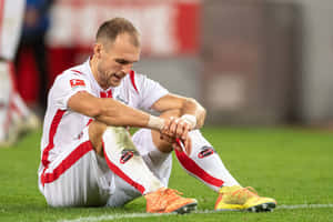 Soccer Player Reflecting After Match Wallpaper