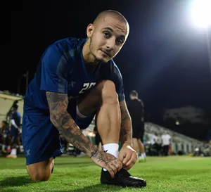 Soccer Player Tying Shoeon Field Wallpaper