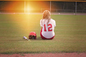 Softball Player Seated On Playing Field Wallpaper