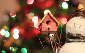 Spread The Winter Cheer With This Beautifully Crafted Birdhouse, Complete With A Snowman. Wallpaper