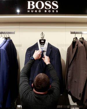 Staff Organizing Merchandise In Hugo Boss Store Wallpaper