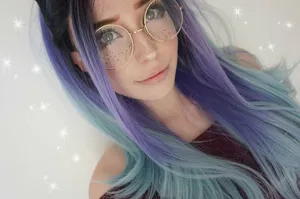Starry Eyed Girlwith Purple Hairand Glasses Wallpaper