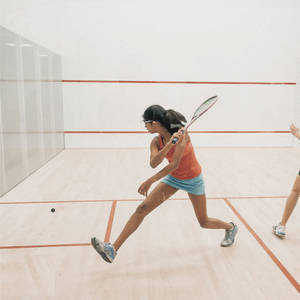 Strong Woman In Orange Playing Racquetball Wallpaper