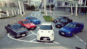 Stunning Fleet Of Skyline Cars Parked Together On A Clear, Sunny Day. Wallpaper